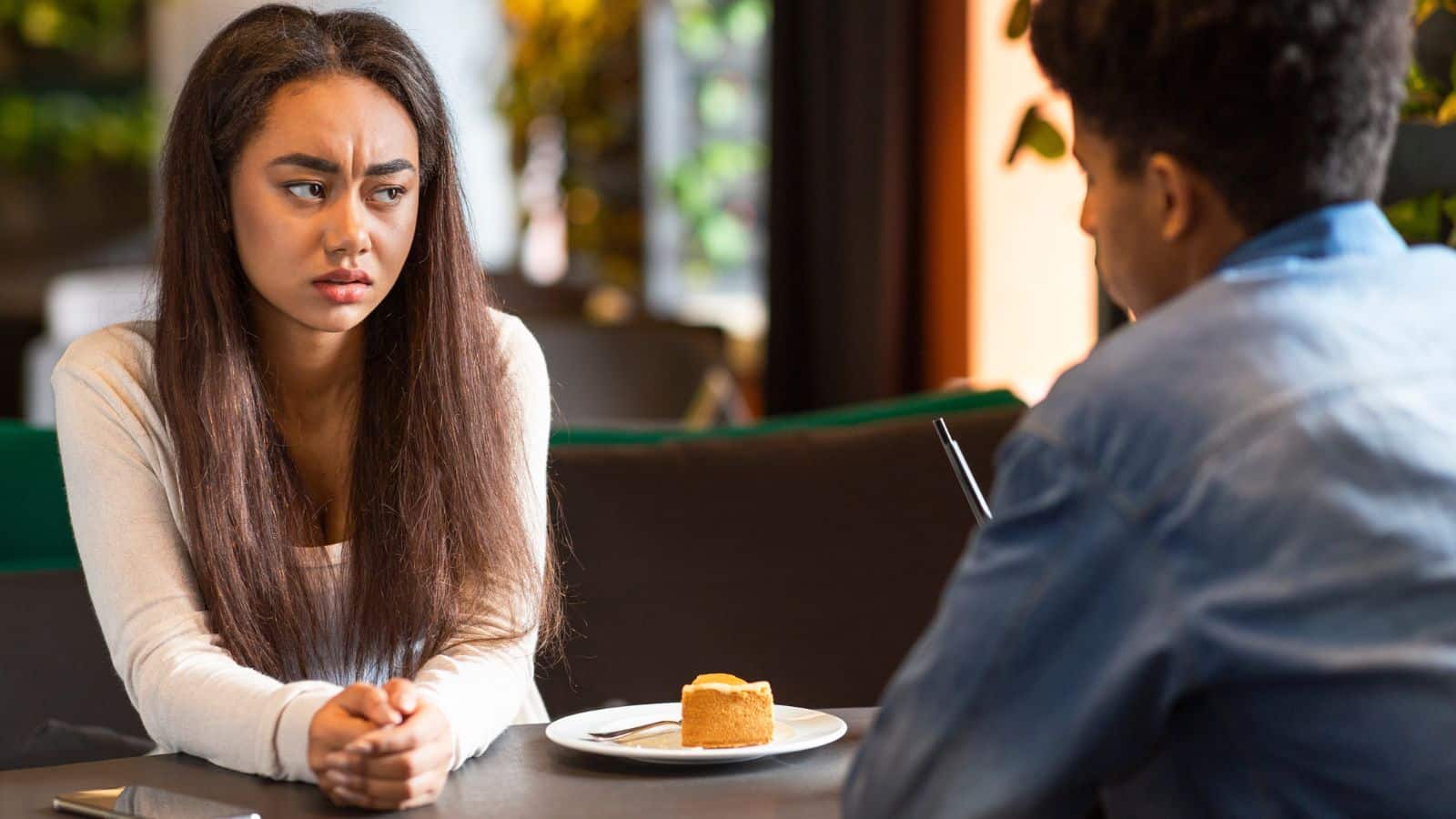 A woman looks concerned when talking to her date, to represent worst first date stories.