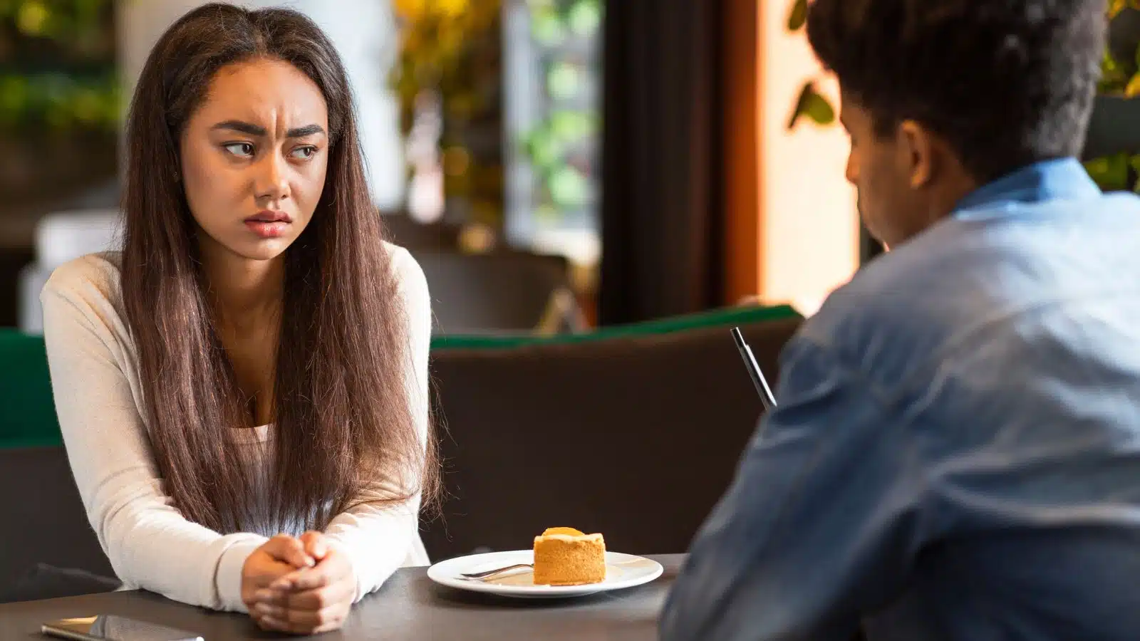 A woman looks concerned when talking to her date, to represent worst first date stories.