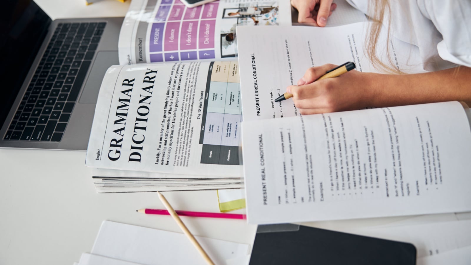 A girl studies English grammar to represent writing exercises. 