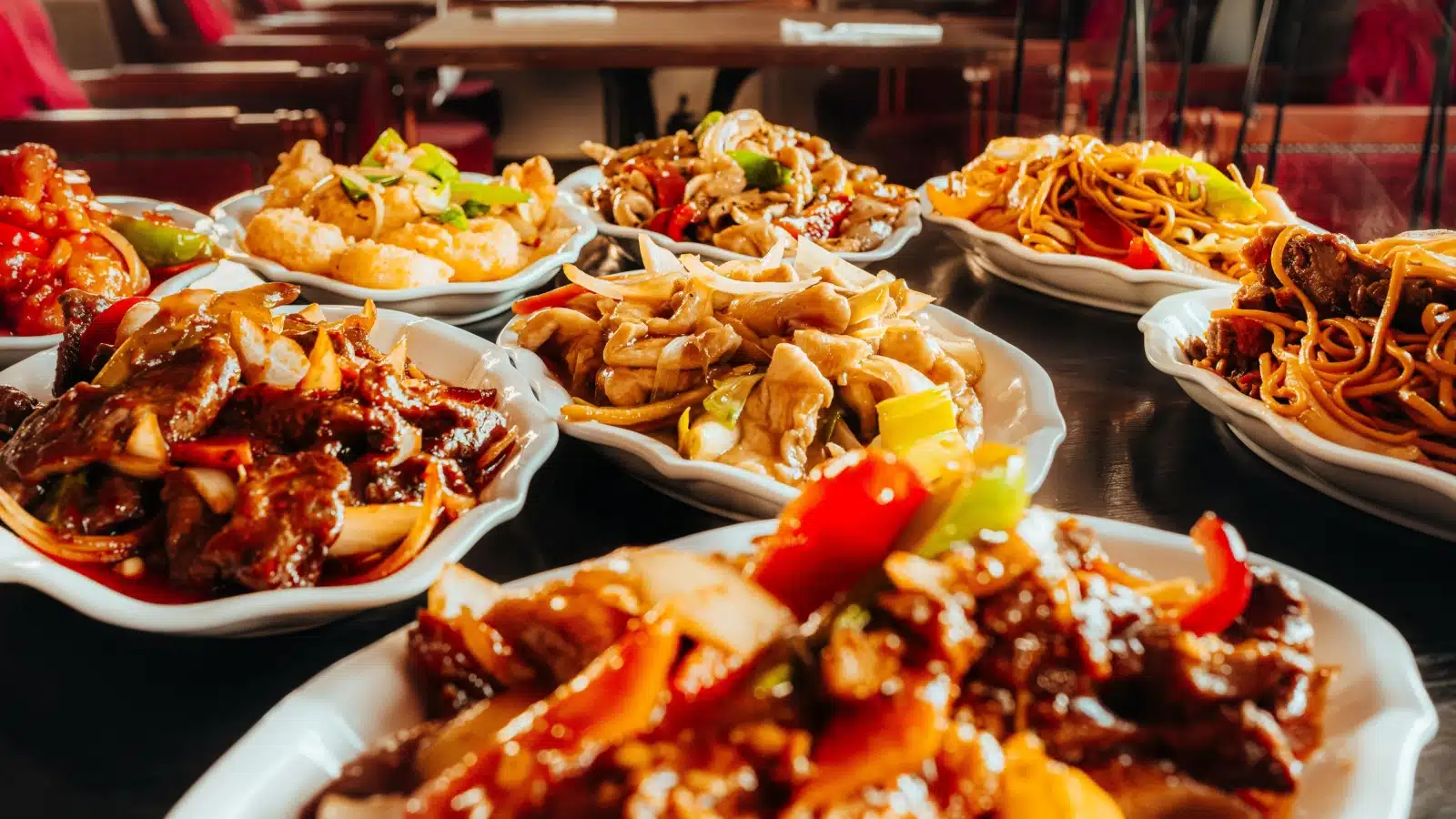 A table with stir fry and noodle dishes to represent Asian food.