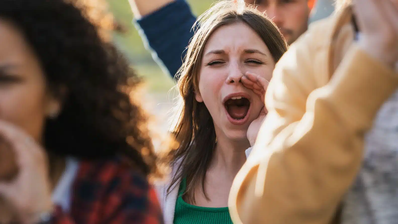 A woman in a crowd yells, advocating for change.