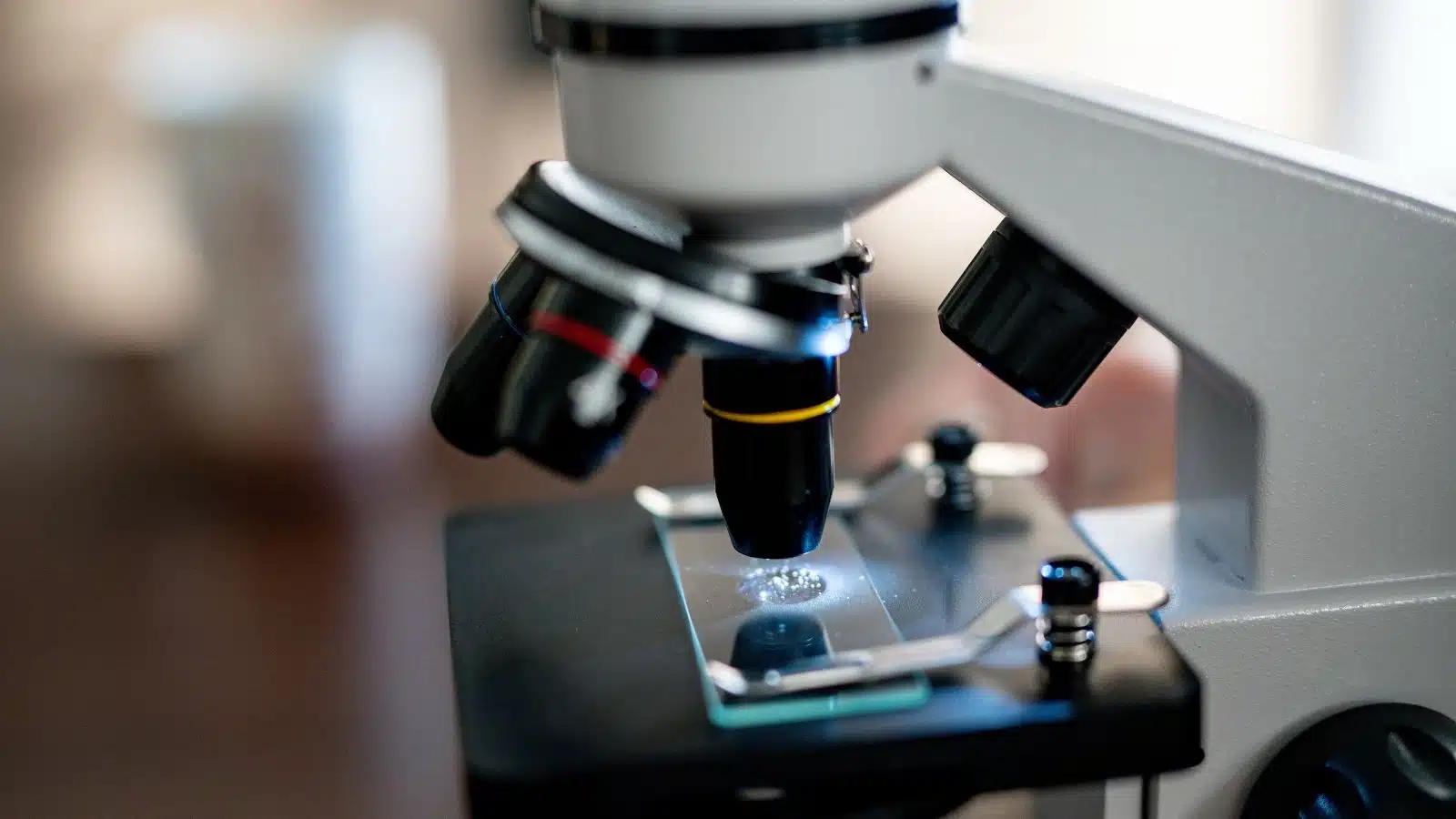 Close up of a microscope with a slide on it.