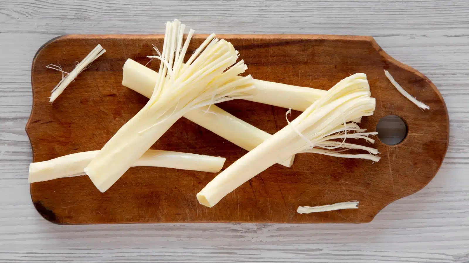 String cheese on a cutting board.