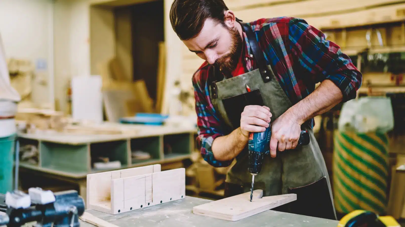 A man makes a birdhouse while enjoying his woodworking hobby.