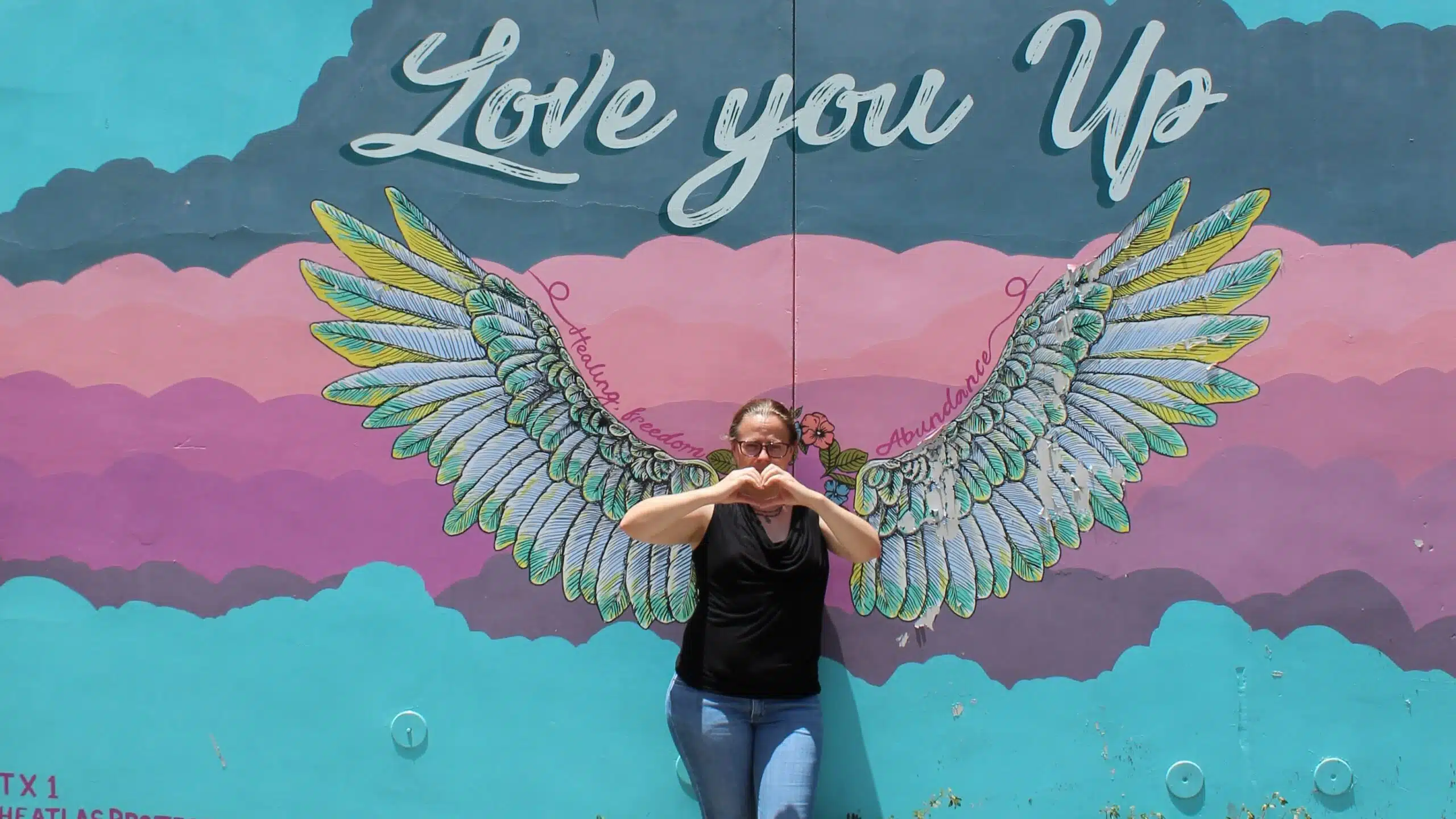Melanie from Partners in Fire standing with one of Ausitn's many murals.