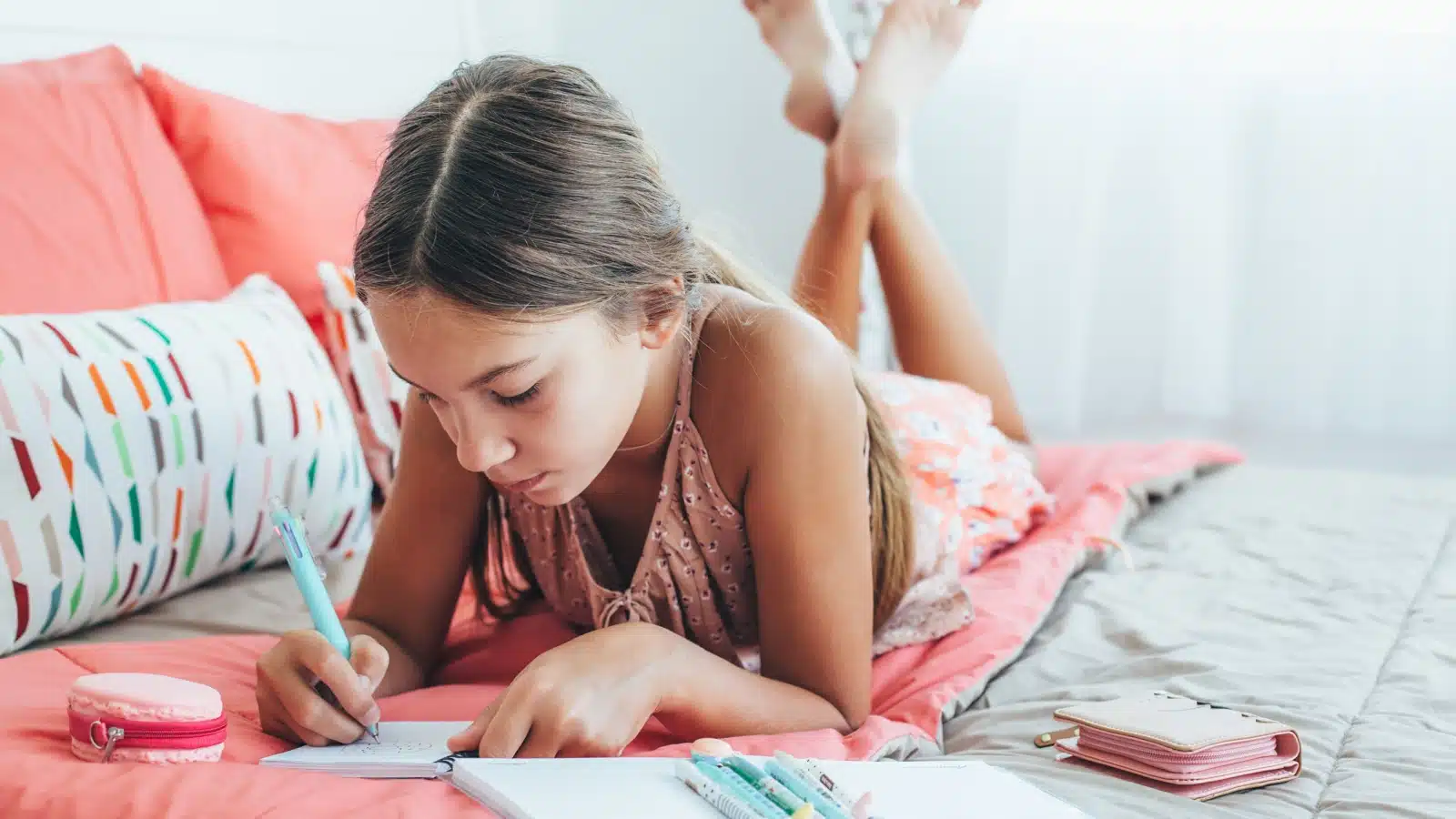 A pre-teen child writing in her journal, representing writing prompts for kids. 