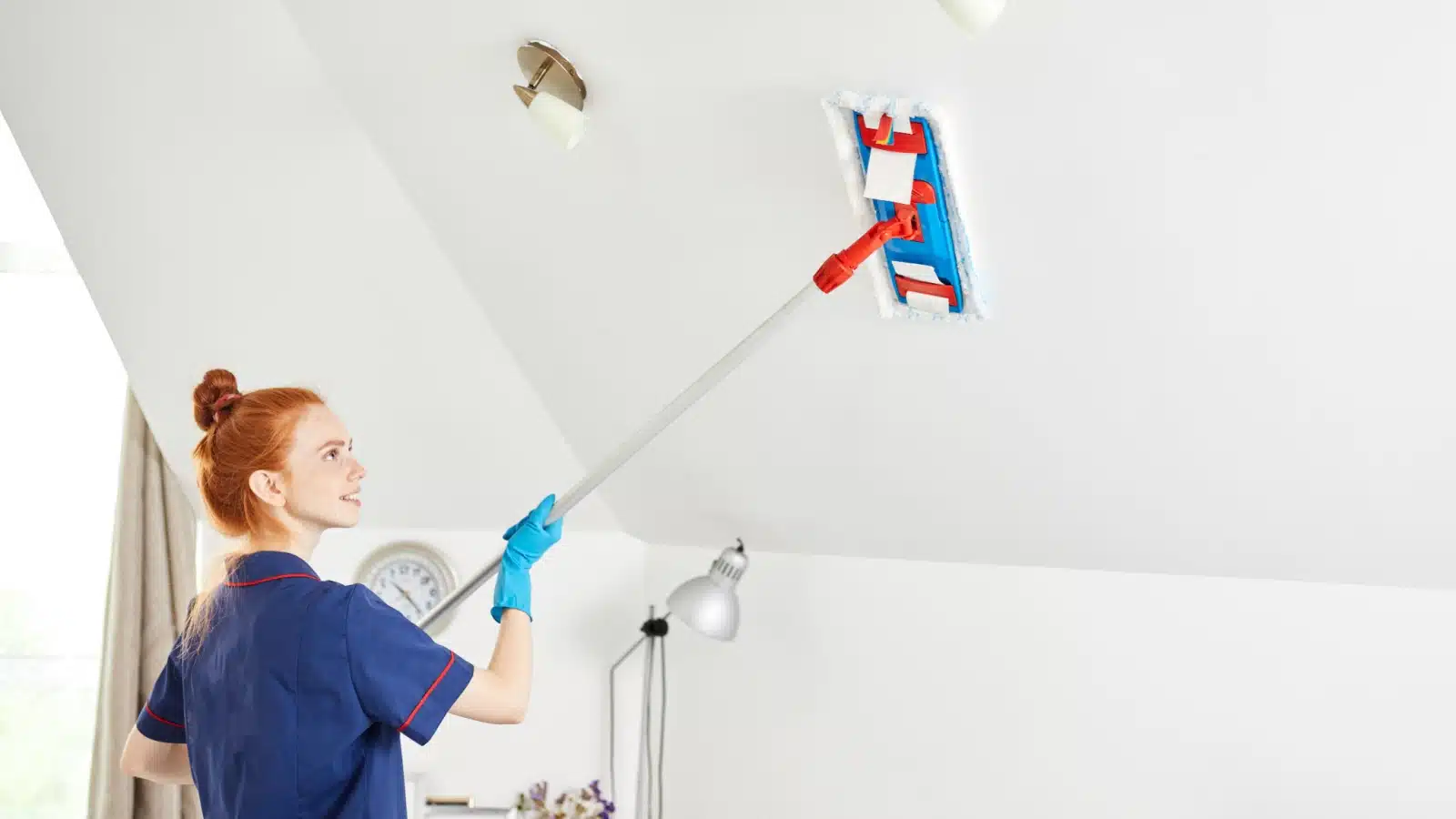 A woman cleans her ceilings.