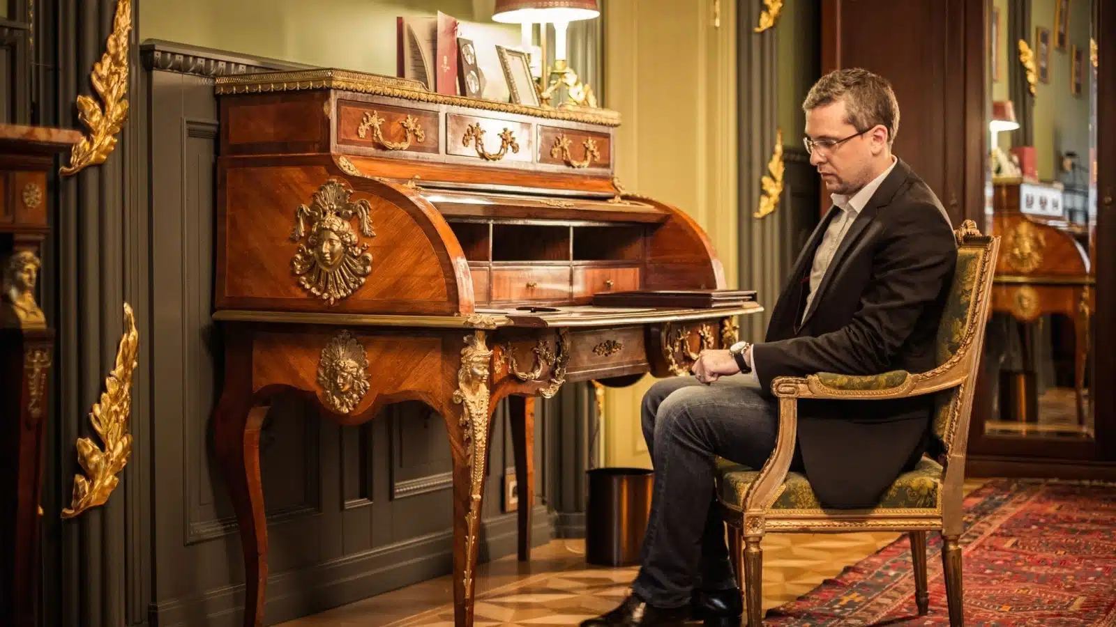 A sad wealthy man sits alone with his riches.