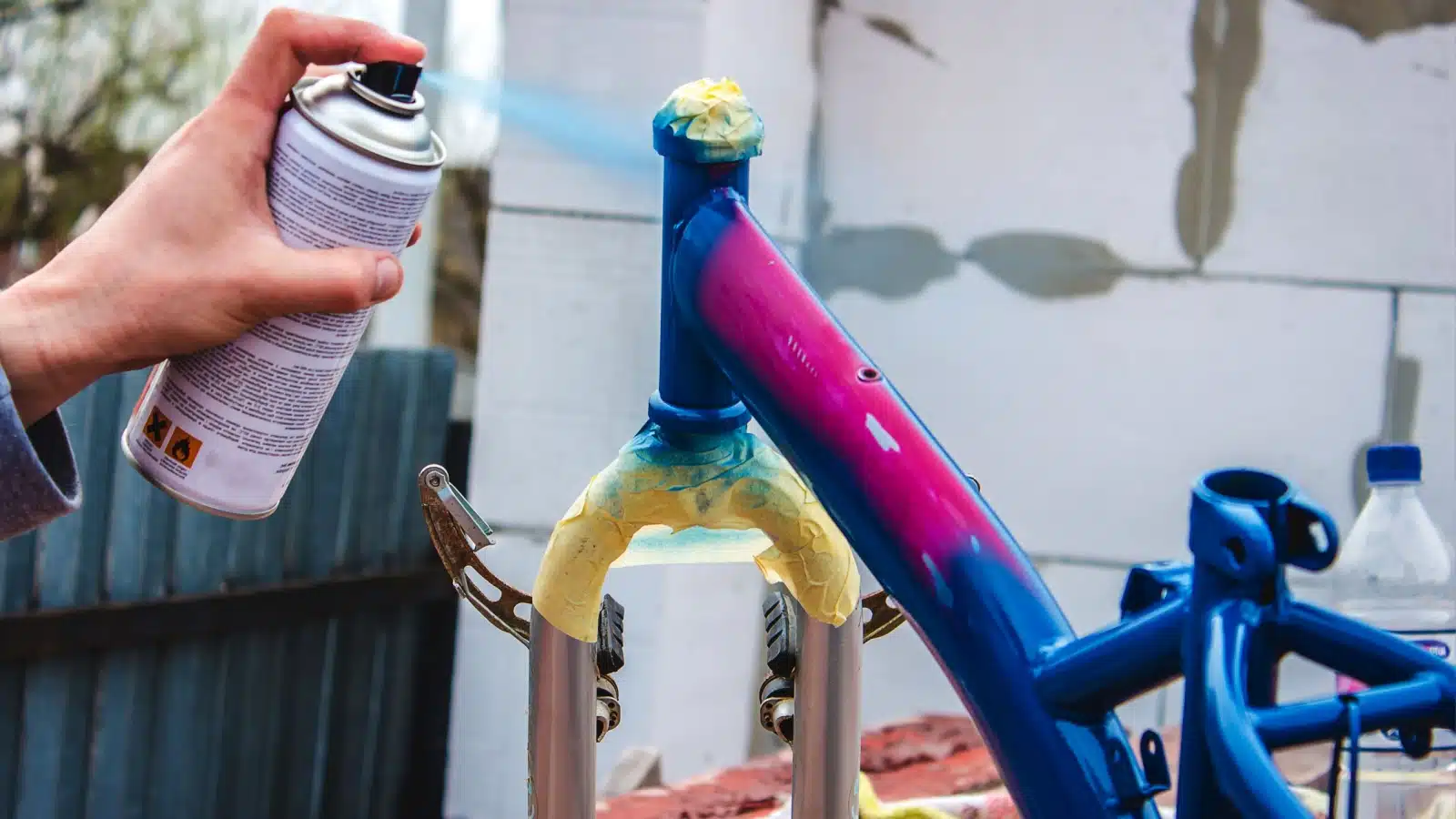 A man spray paints a bike.