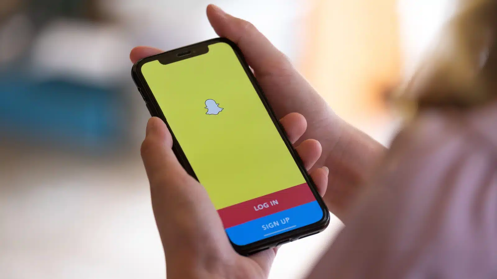 Man opening the snapchat app on his phone.