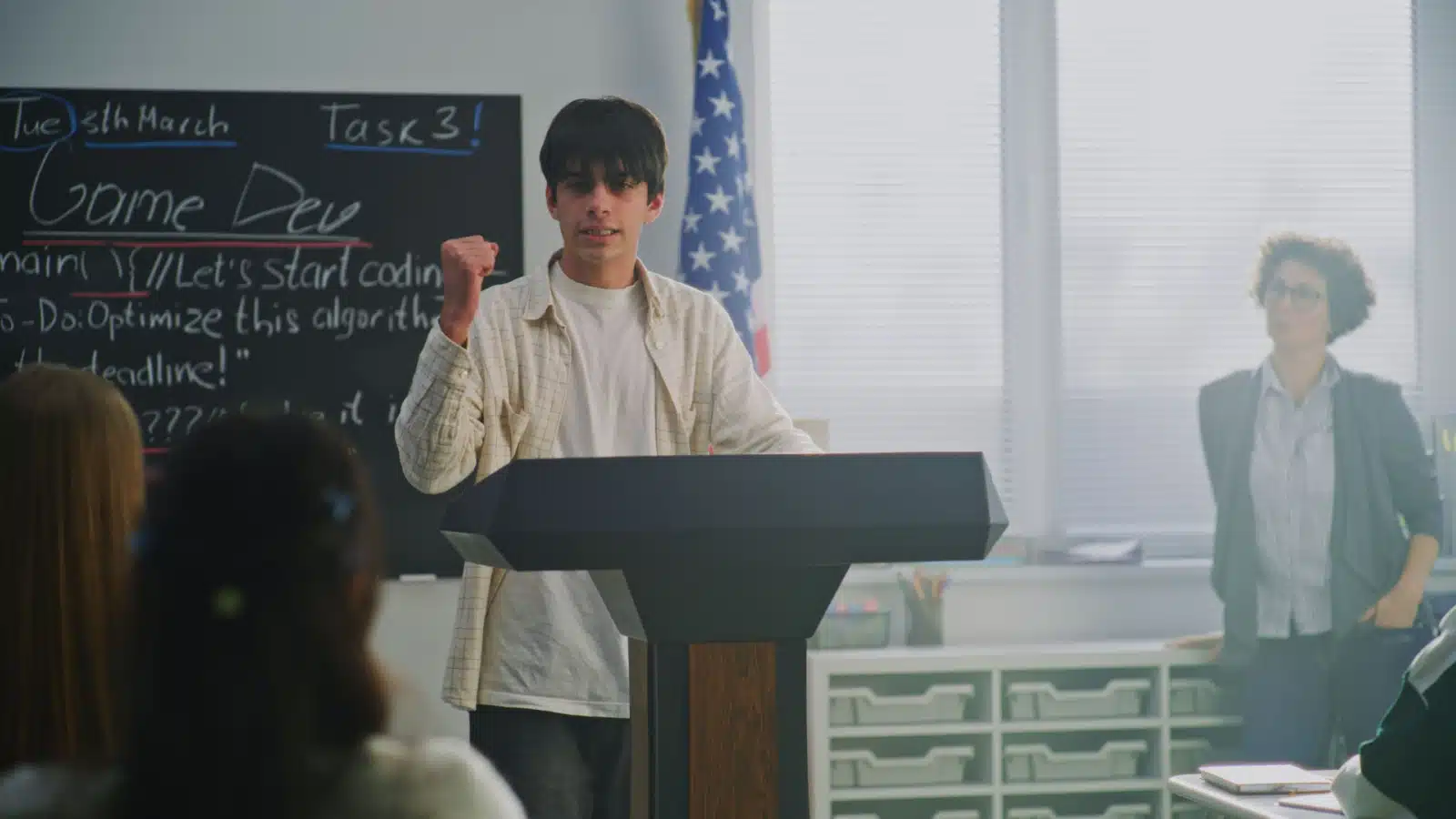 A student stands at a podium giving a passionate speech to help us define passion.