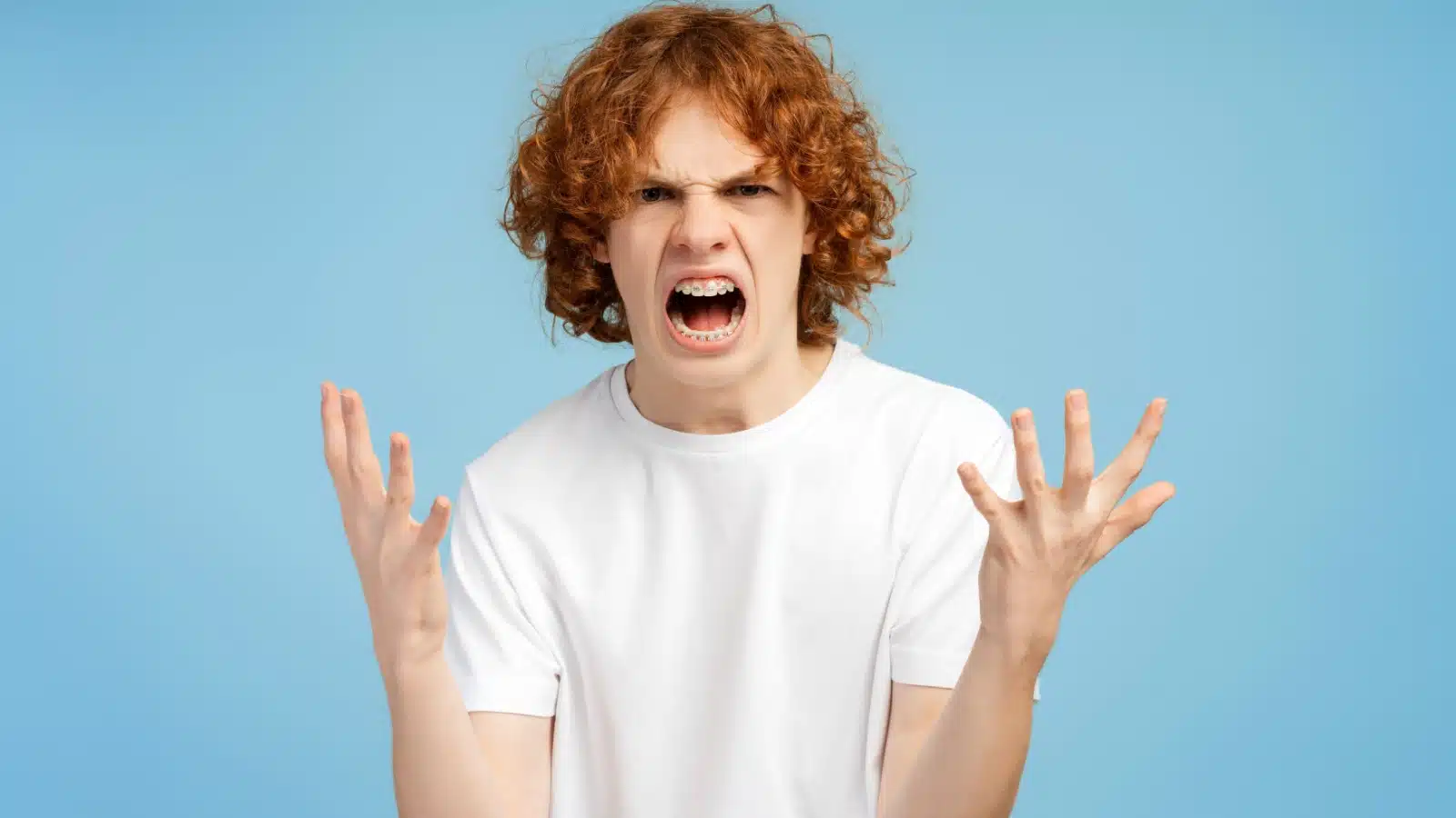Angry teenage boy yelling.