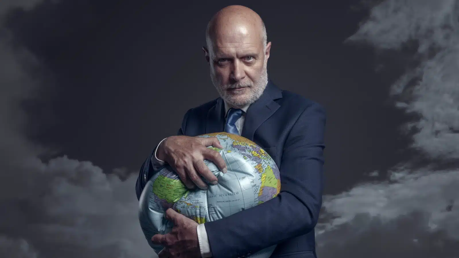 An evil businessman crushes a globe in his arms, representing the stranglehold big businesses have on society.