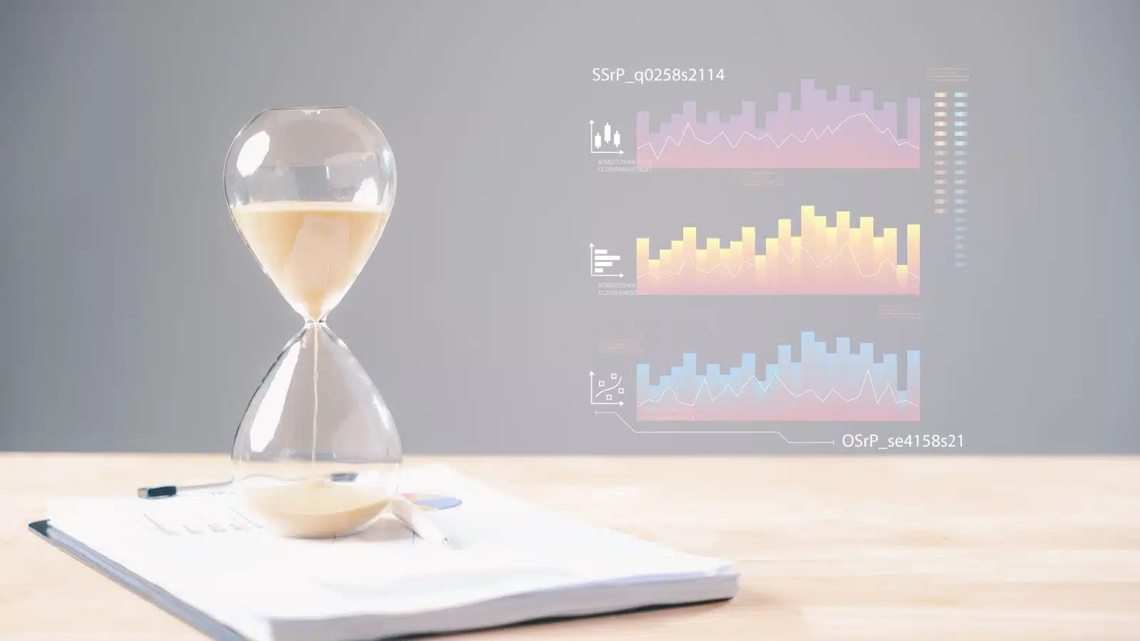 An hourglass rests on financial paperwork, while subdued images of stock charts appear in the background, to represent investment timeframes.