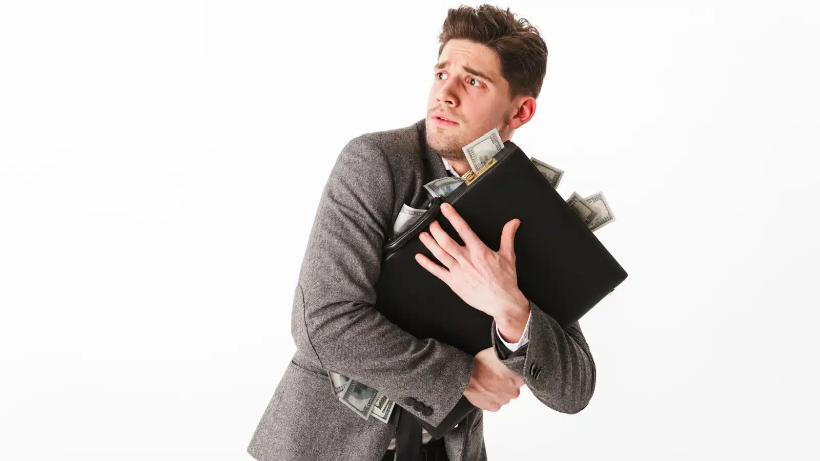 A scared man clutches a briefcase full of dollars to represent hoarding cash.