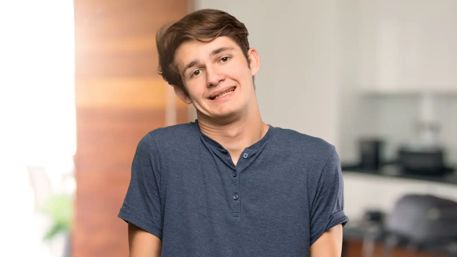 A teenage boy smiles awkwardly because he doesn't know what to do.