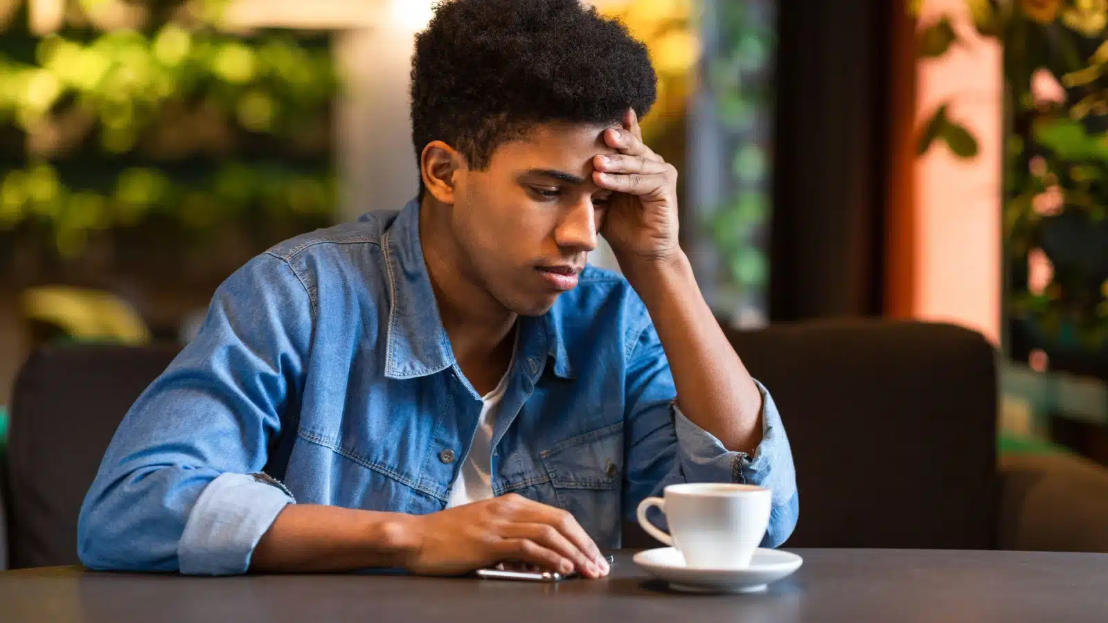 An unsure teenager contemplates life while sitting in a coffee shop.