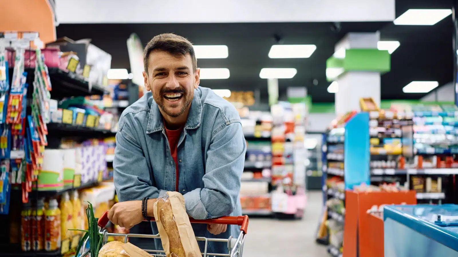 A happy man grocery shopping.
