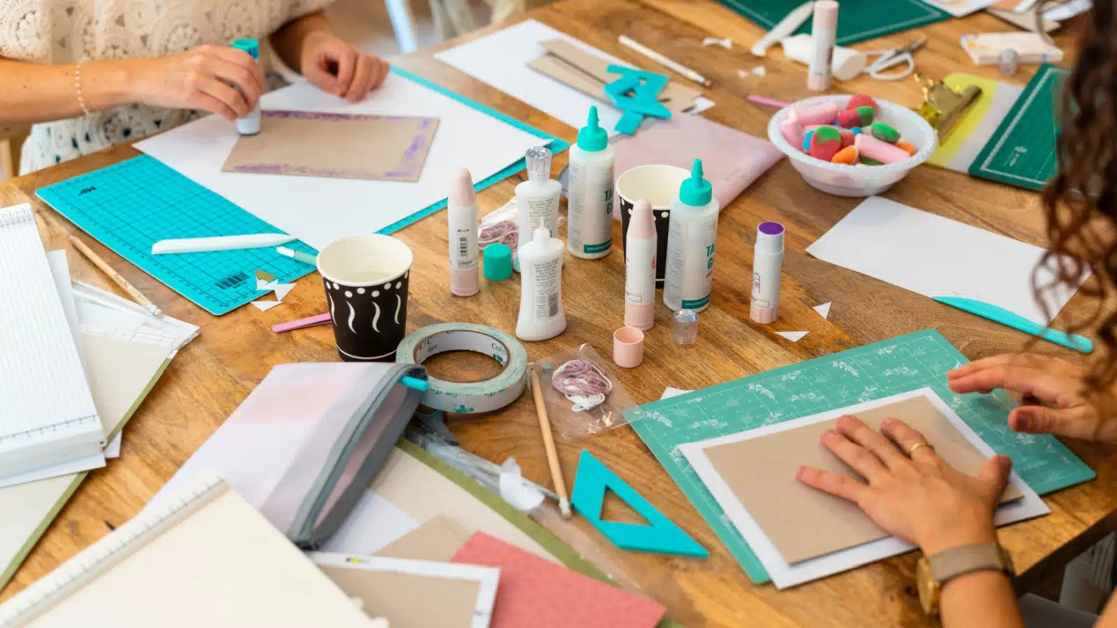 Friends working on scrapbooks and art journals together.