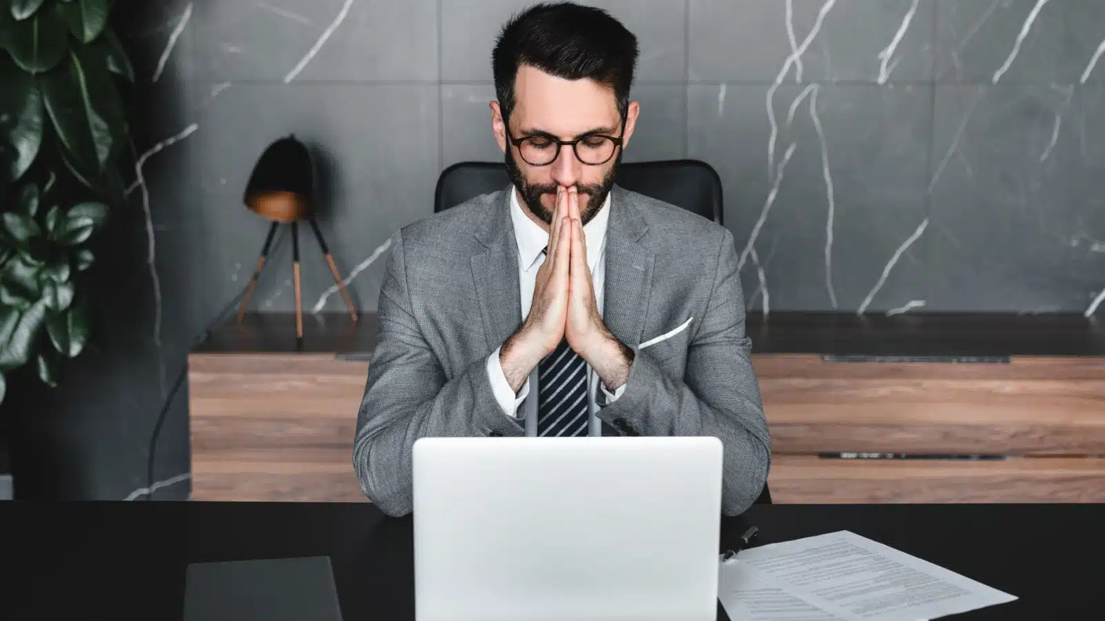 A man pauses at work to think deeply about a task before responding.