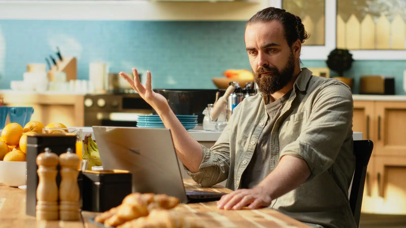 An unsure confused man sits at his laptop. He doesn't know what to do next.