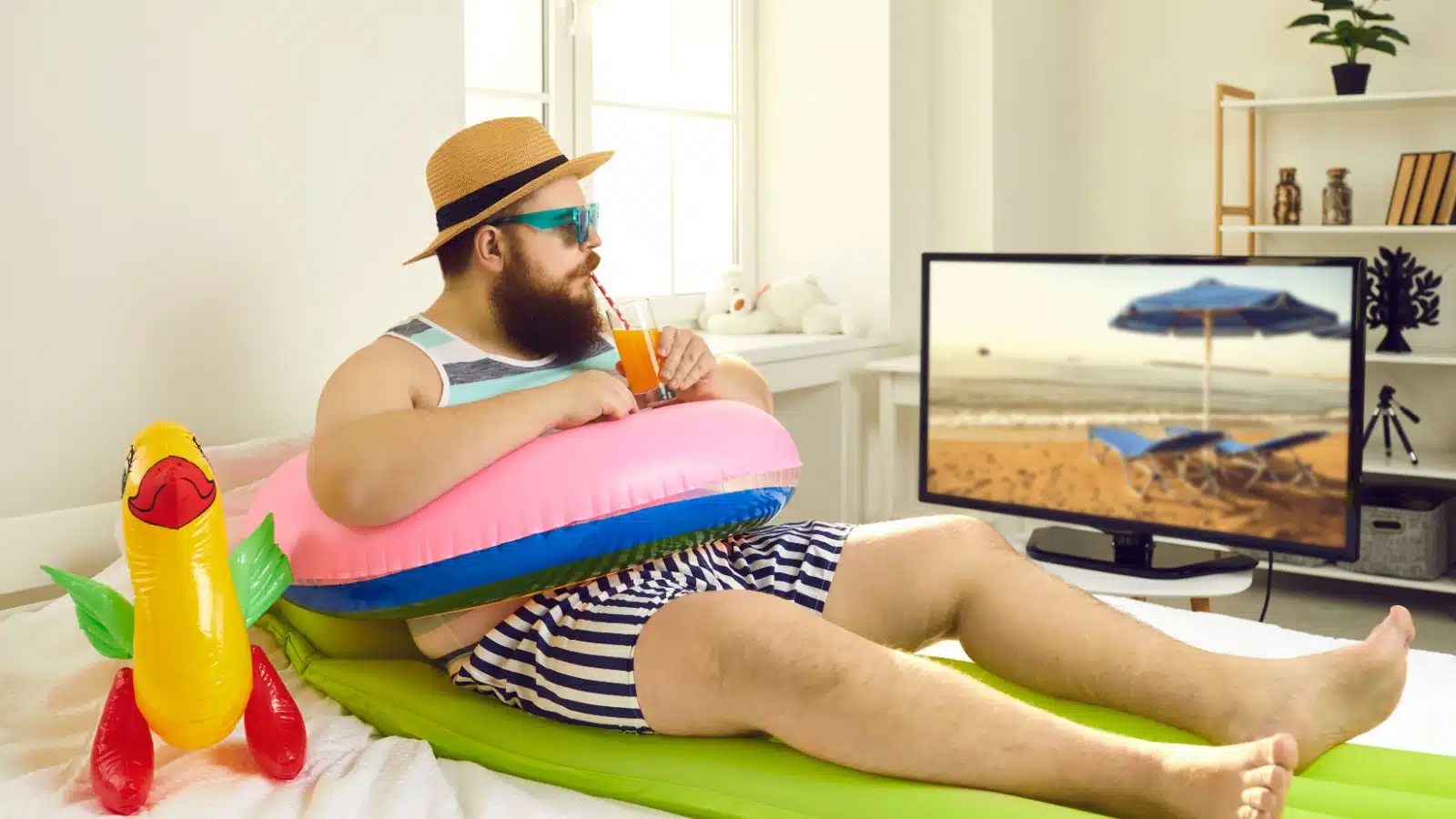A man with beach tubes sitting inside watching tv. 