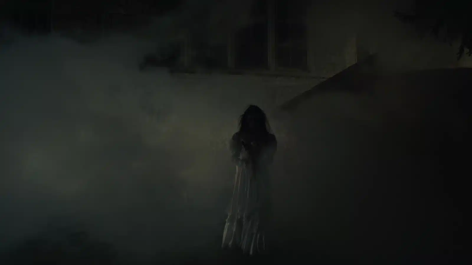 Creepy darkened image of a ghost wearing a white dress. 