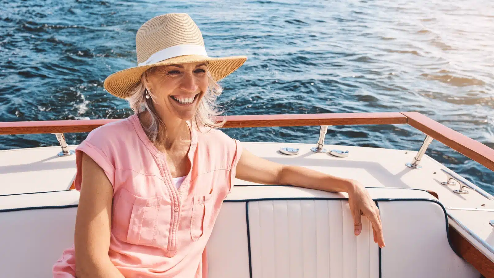 A happy older woman enjoying a summertime boat ride. 