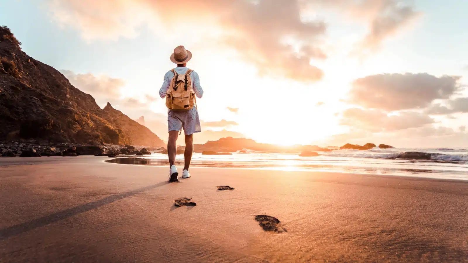 A solo traveler enjoying a serene beach at sunrise. 
