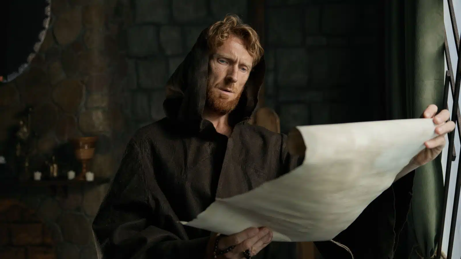 A monk reads from an ancient scroll to represent incantation and the power of words.