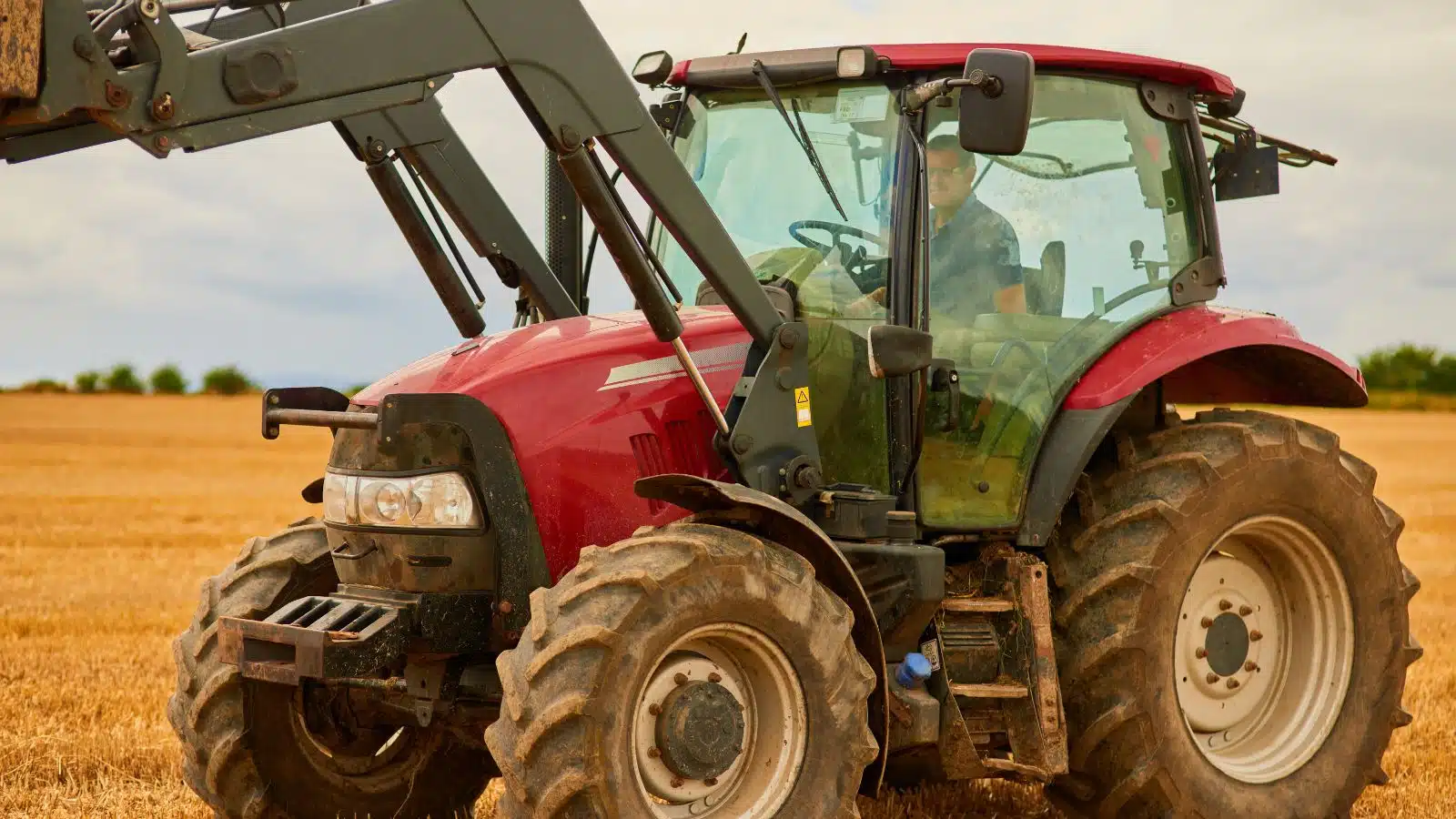 A farmer driving a red tractor.
