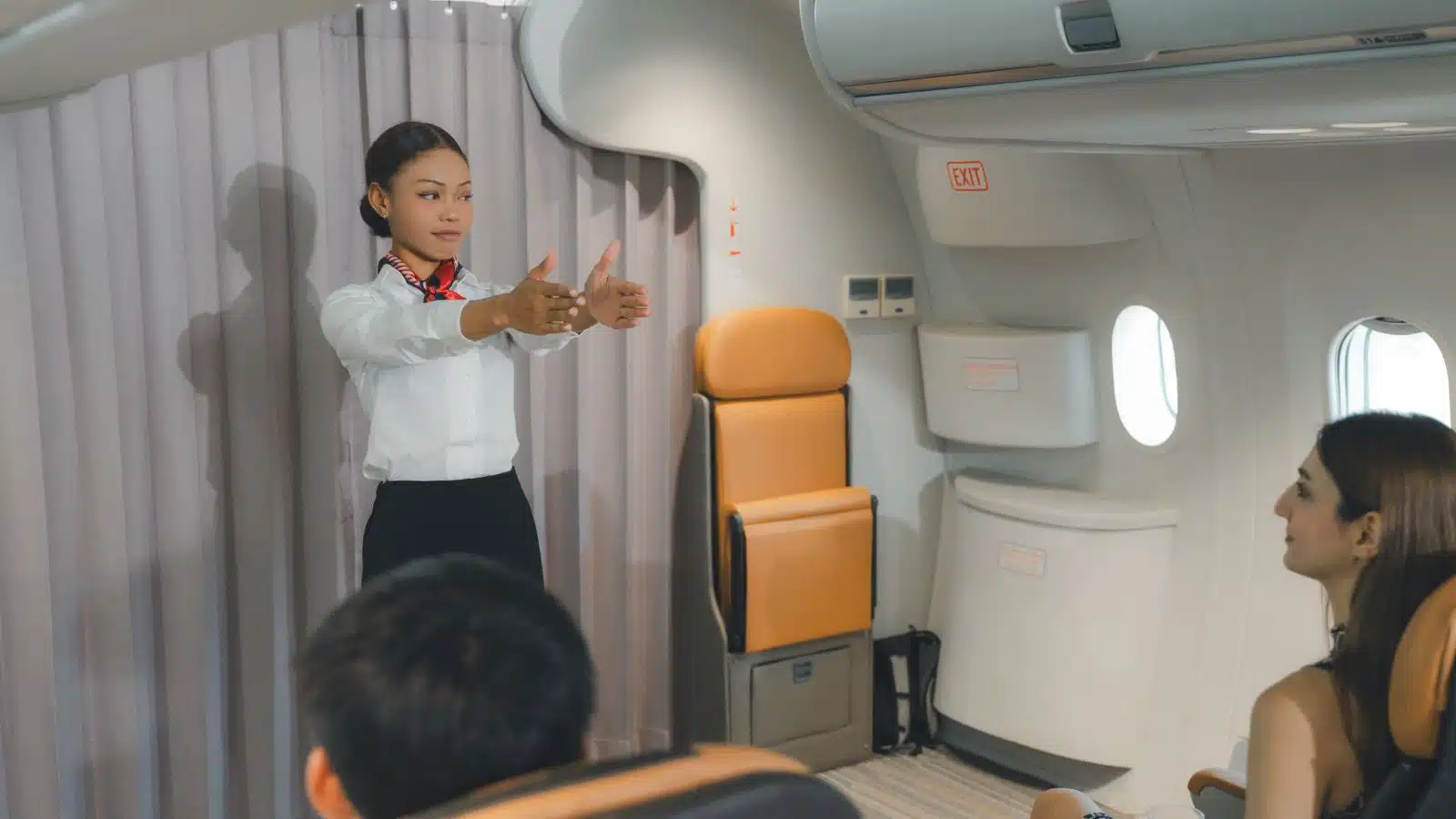A flight attendant giving the safety demonstration before take off.