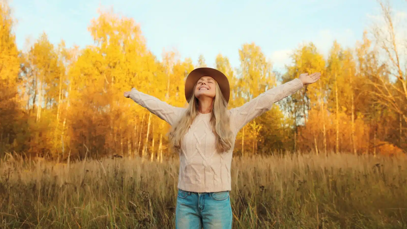 A woman enjoys the sunlight on an autumn day. 