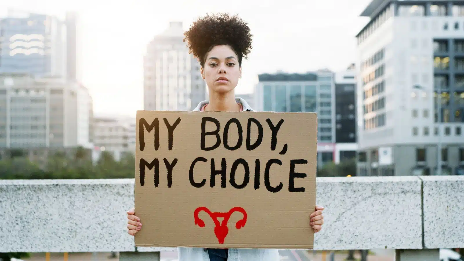 A woman holds a "my body my choice" sign to protest for women's rights.