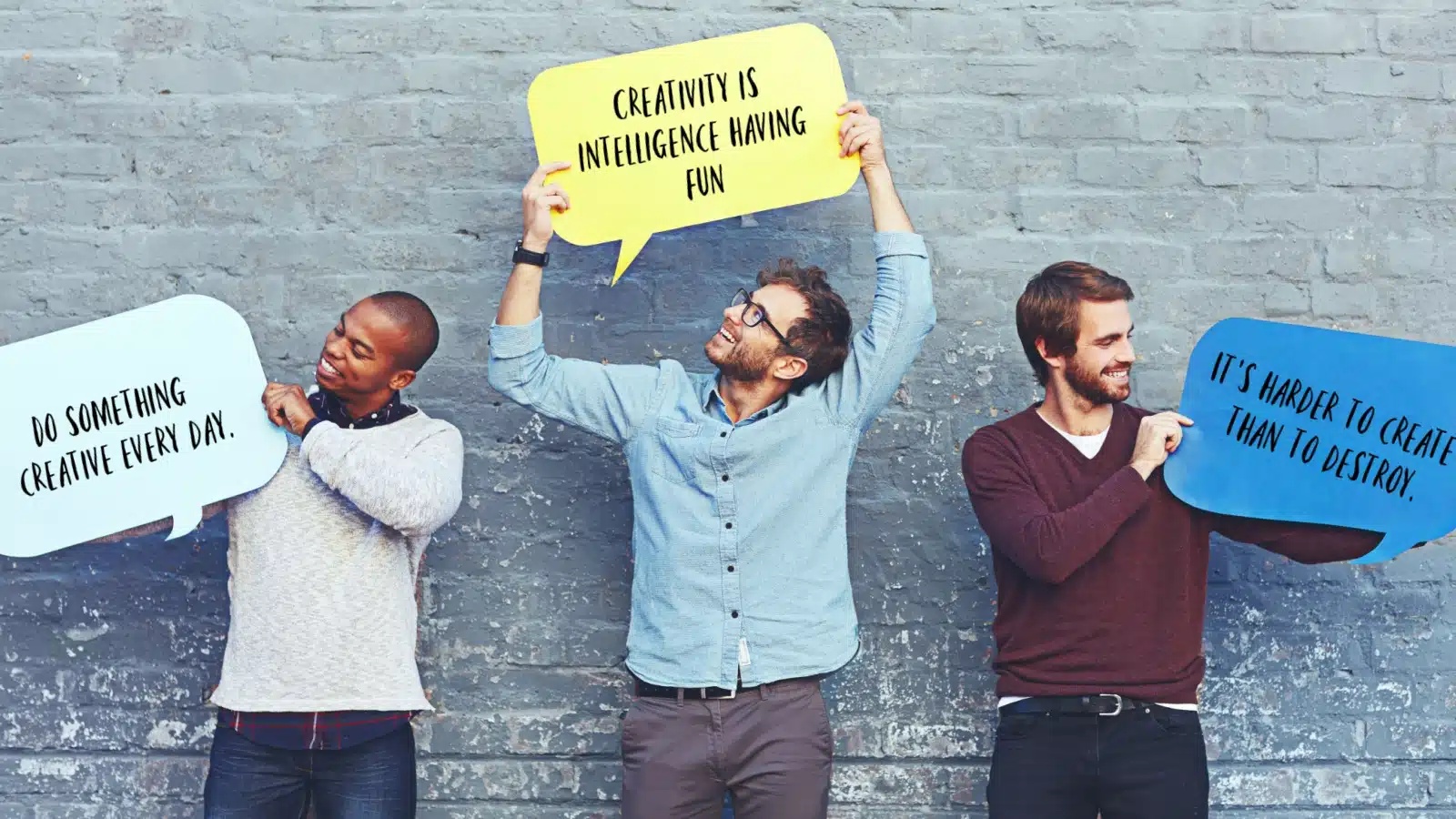 Men holding dialogue signs with quotes about creativity written on them. 
