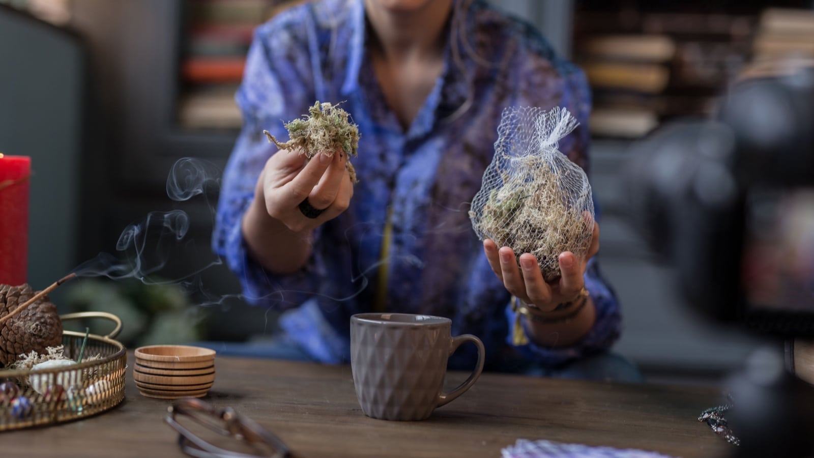 A modern witch casting a spell with herbs and tea.