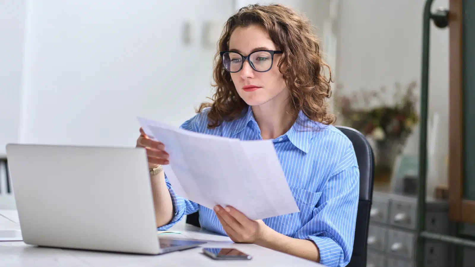 A woman examines documents for a job.