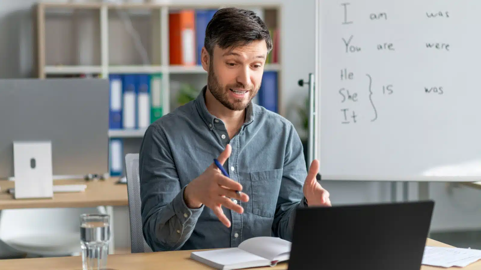 A man tutors a student online.