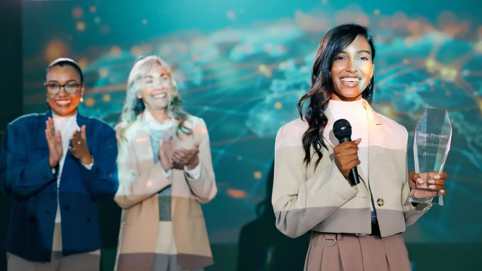 A proud woman receives an award on stage in recognition of her accomplishments.