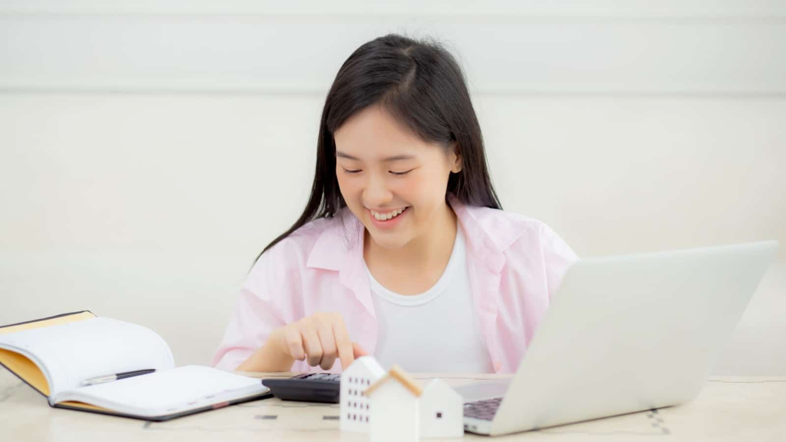A happy woman reviews her budget to decide "Can I afford a home?"