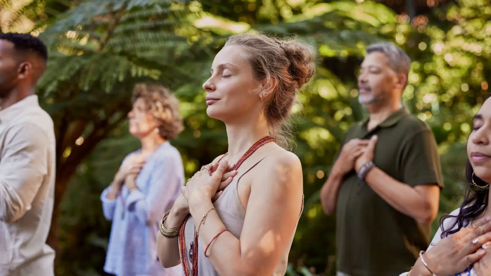 A group of people practicing deep breathing to represent emotional well-being and mindfulness.