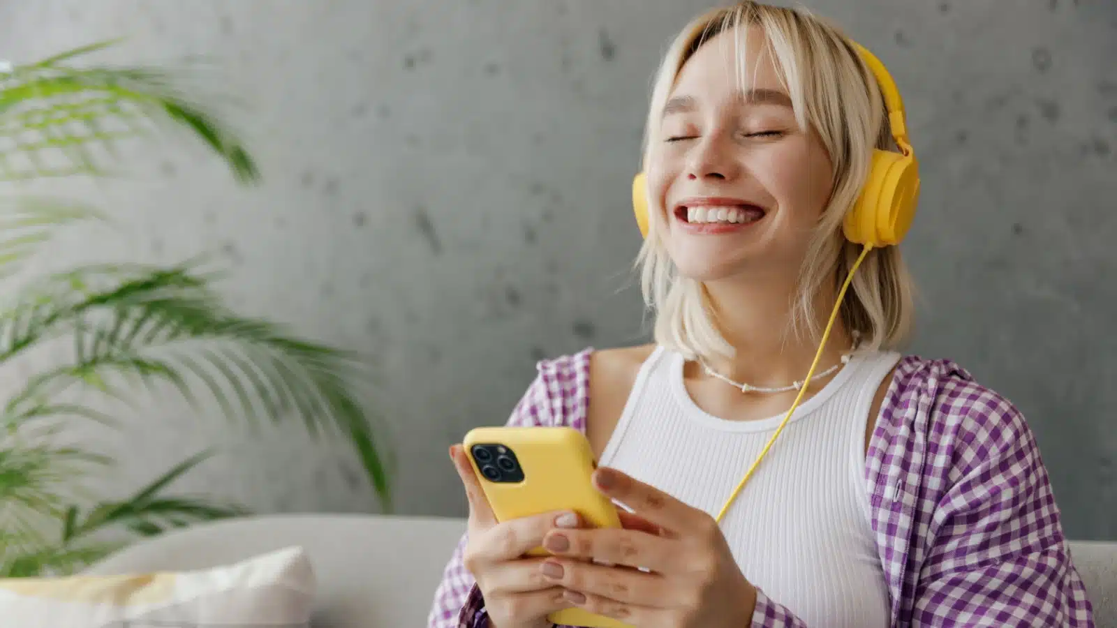 A happy woman listens to music from her curated playlist.