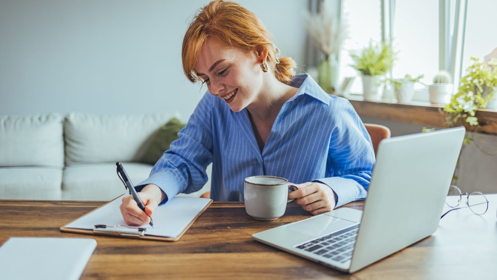A woman sits at her desk, making an action plan.