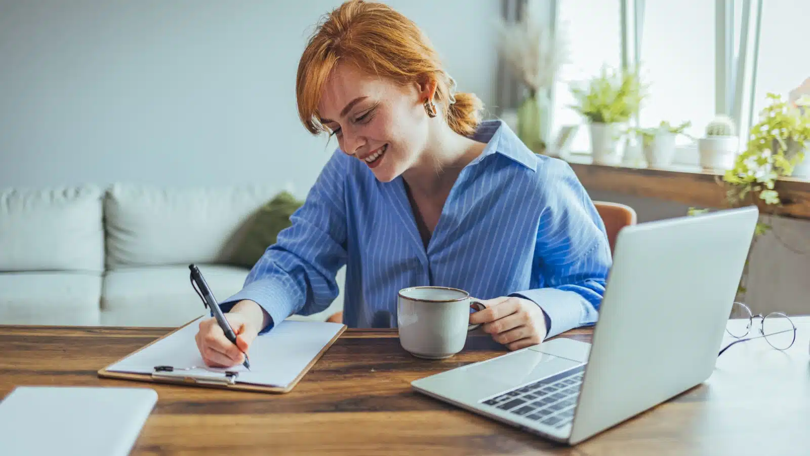 A woman sits at her desk, making an action plan.