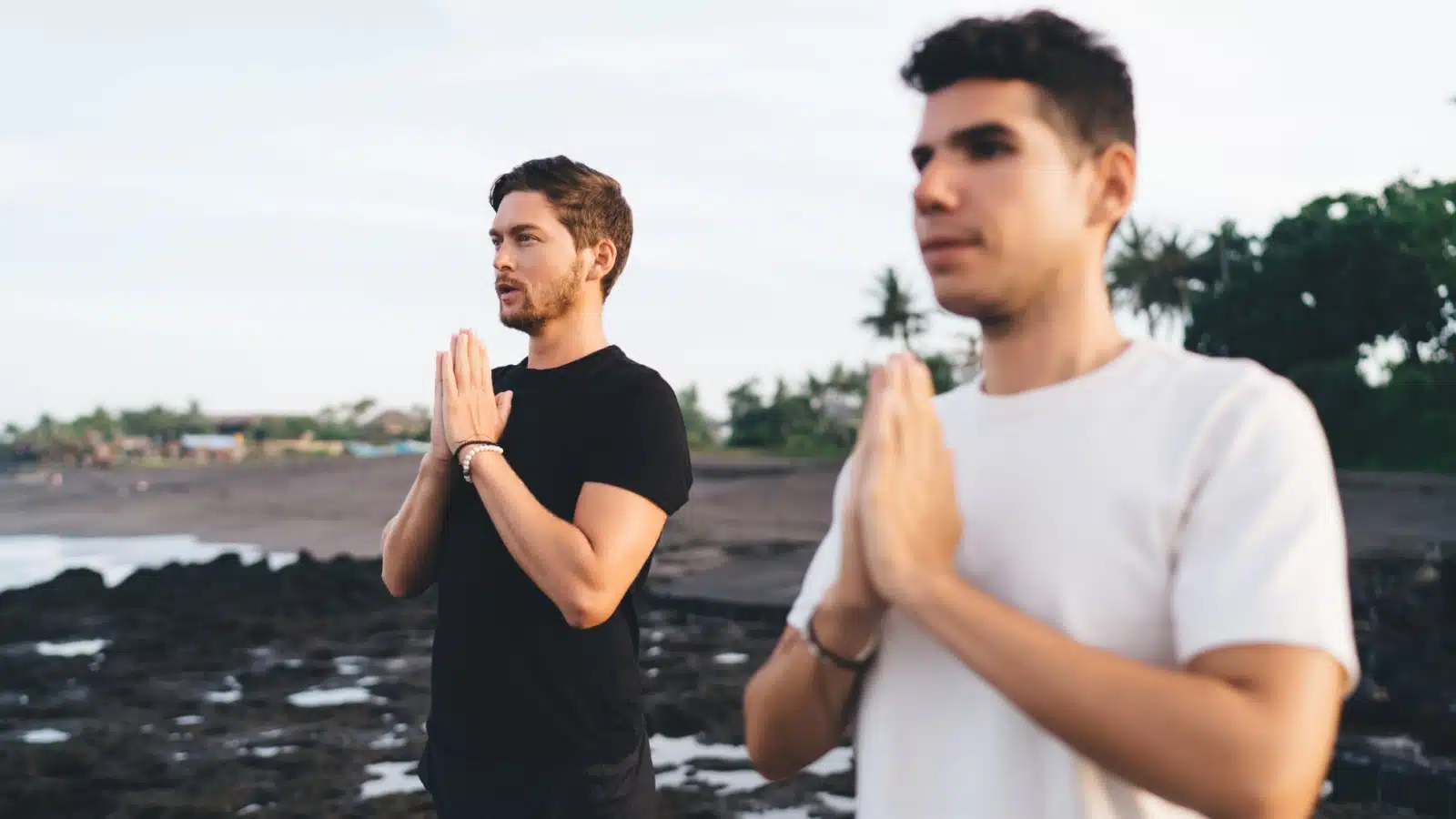 Two men practicing yoga outside to strengthen self-discipline.