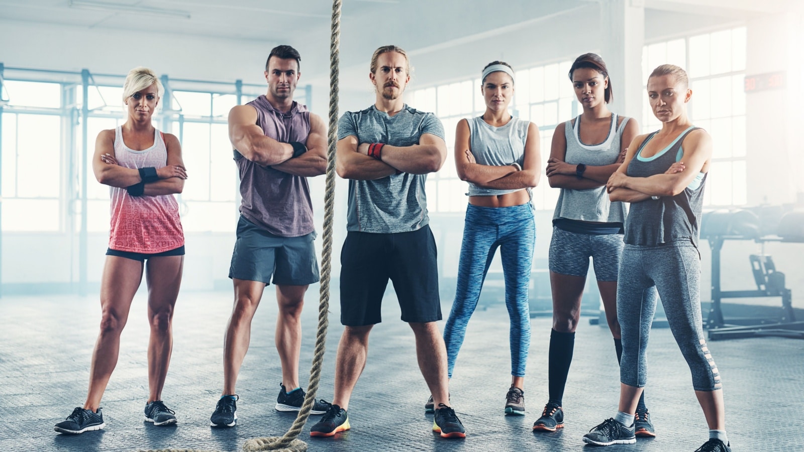 A group of people at a gym standing around a rope, to represent why challenging yourself matters.