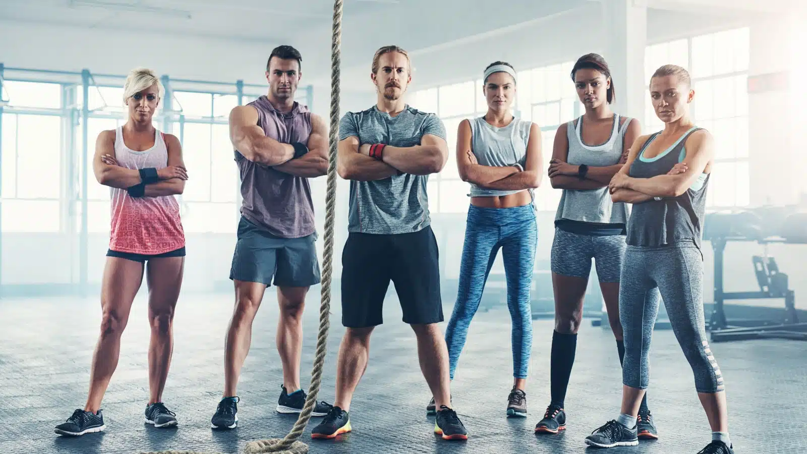 A group of people at a gym standing around a rope, to represent why challenging yourself matters.