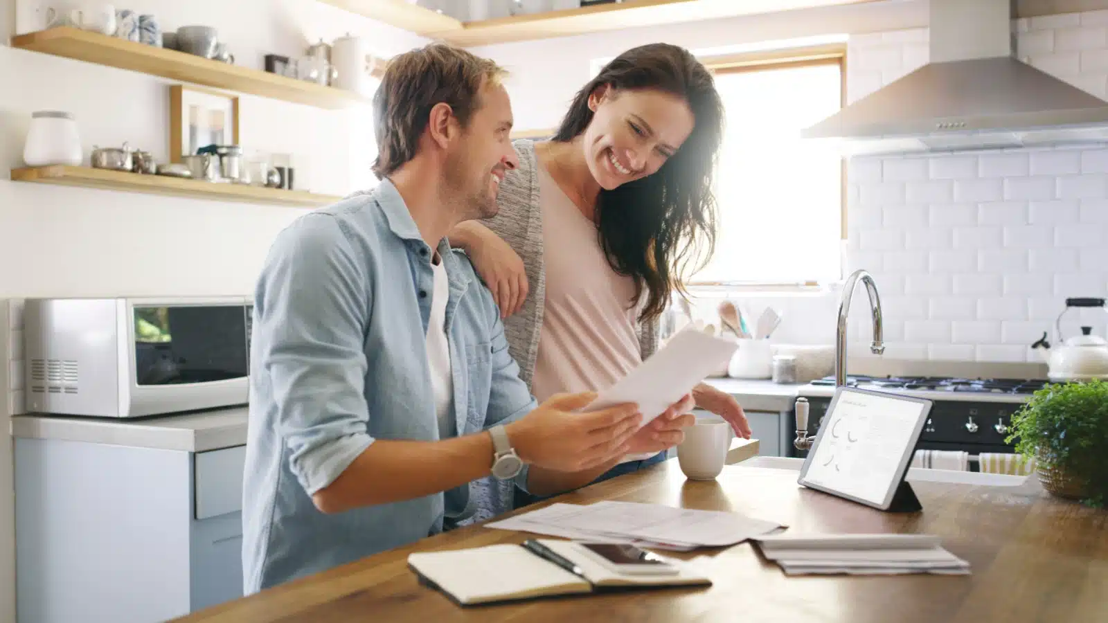 A happy couple reviews their finances to represent how to budget.
