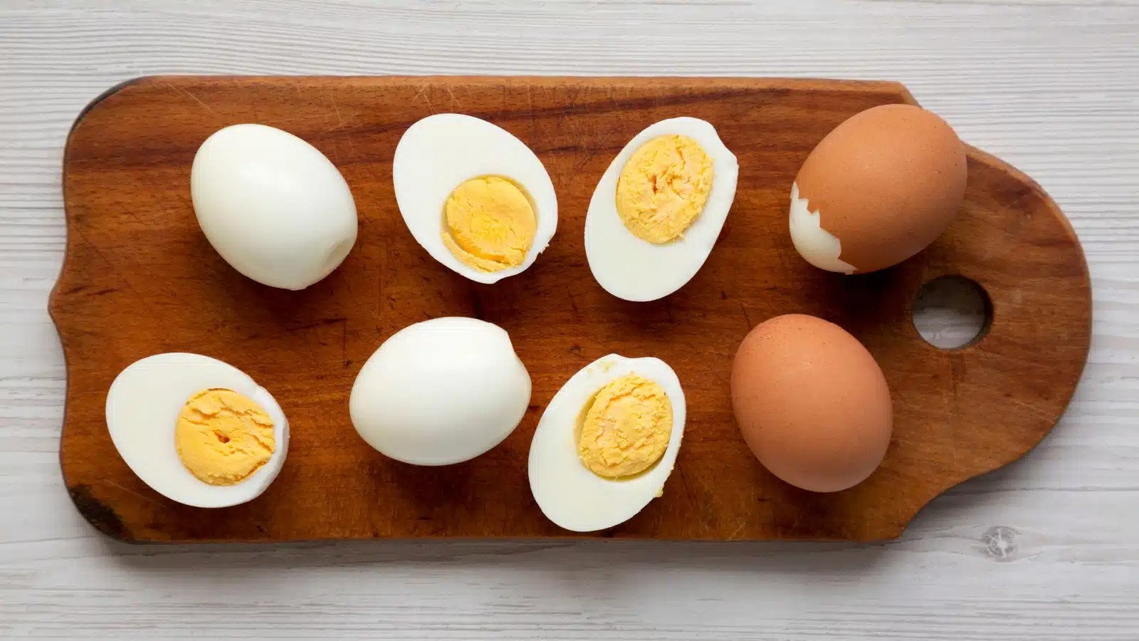 A wooden tray with perfectly cooked hard-boiled eggs.