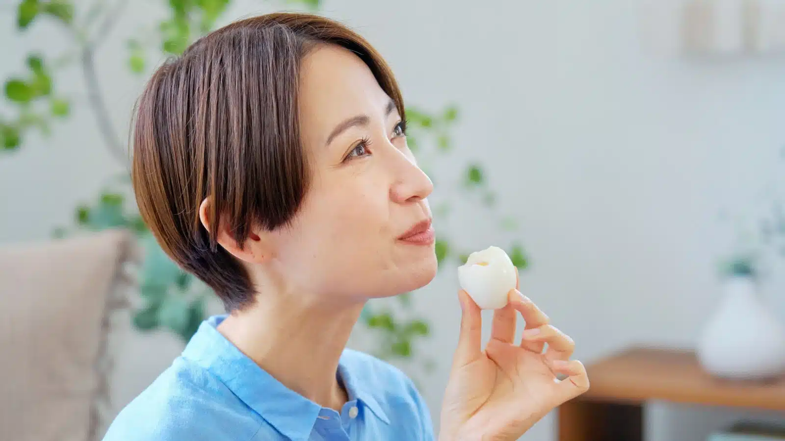 A woman eats a perfectly cooked hard boiled egg.